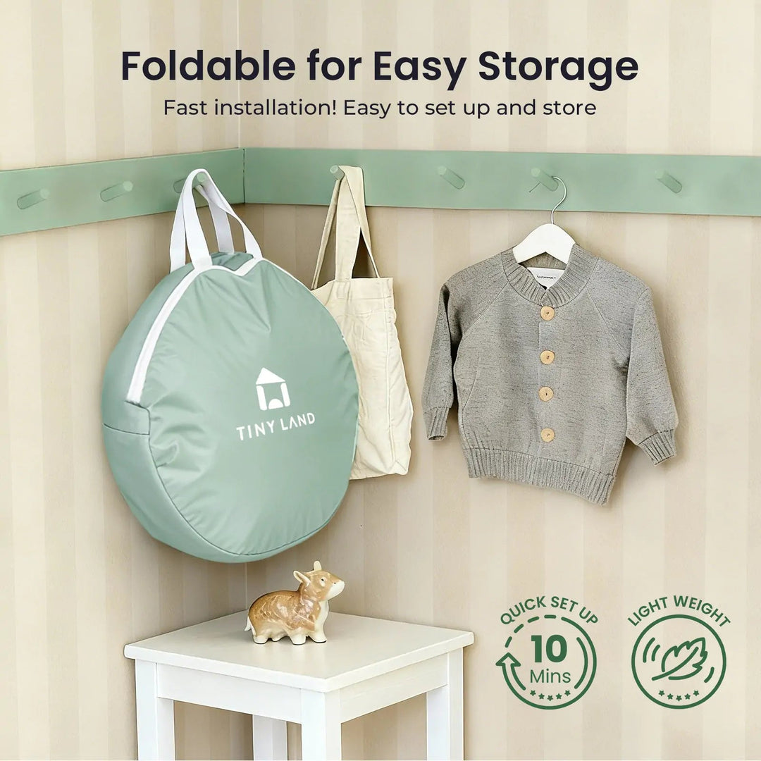 Sea Dragon Dreams Tiny Land 3-in-1 play tunnel in a sage green portable storage bag hanging on a wall hook.