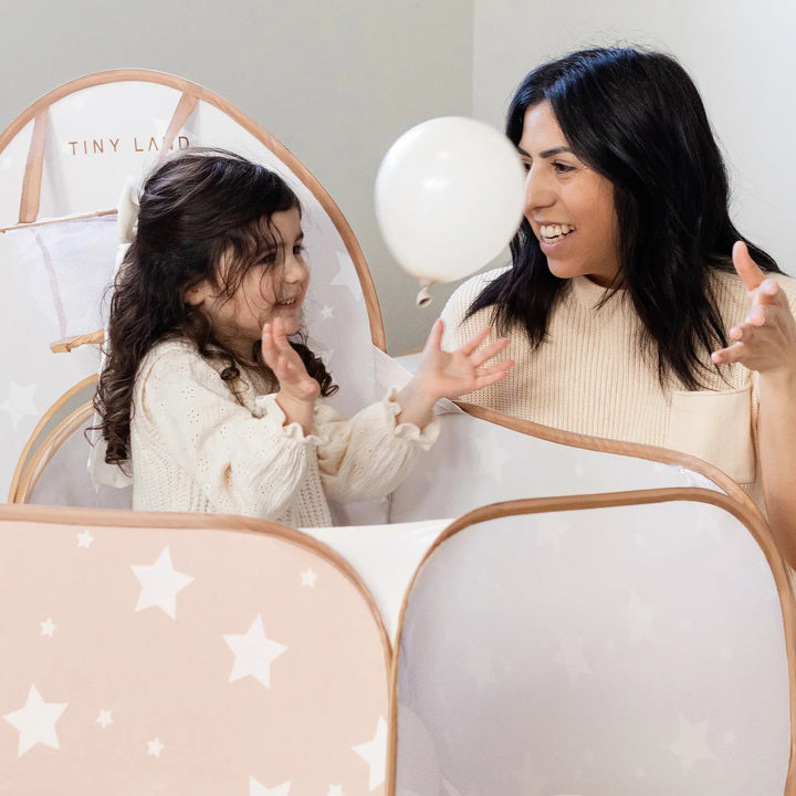 Sea Dragon Dreams Tiny Land 3-in-1 beige play tunnel with star patterns and mesh sides, featuring a mother and daughter.