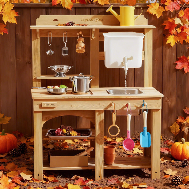 Sea Dragon Dreams Tiny Land wooden mud kitchen with working faucet, sink, and accessories in an autumn garden setting.
