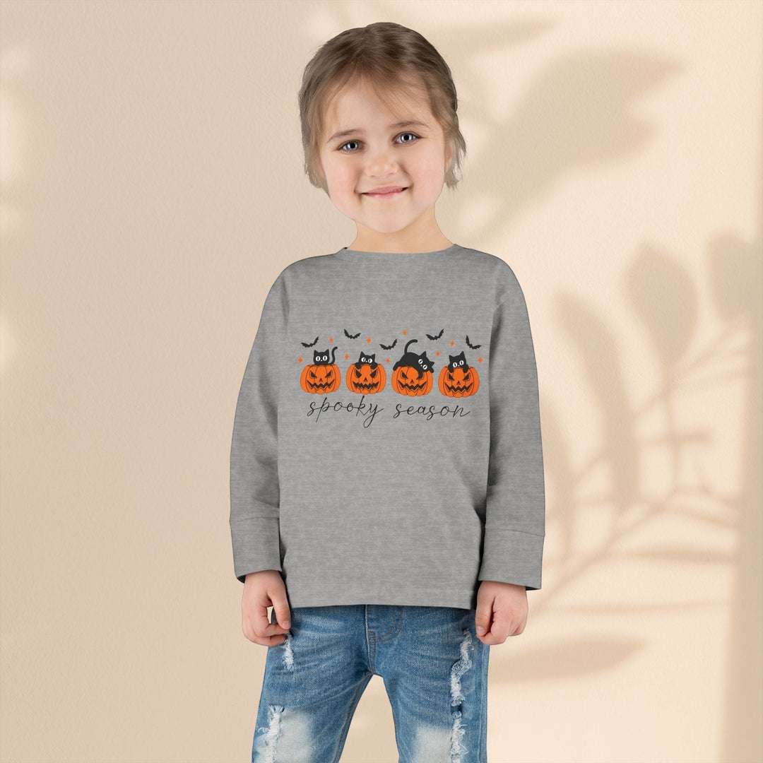 Sea Dragon Dreams toddler wearing a grey long sleeve Halloween tee with a pumpkin and black cat spooky season print.