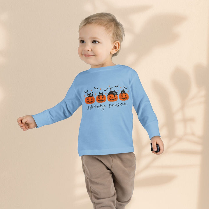 Sea Dragon Dreams toddler wearing a light blue long sleeve Halloween tee with a pumpkin and cat print