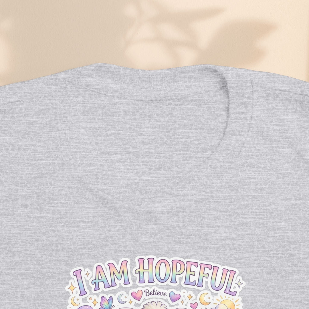 Sea Dragon Dreams toddler tee in heather grey cotton with I Am Hopeful graphic featuring Hope Bunny and pastel icons.