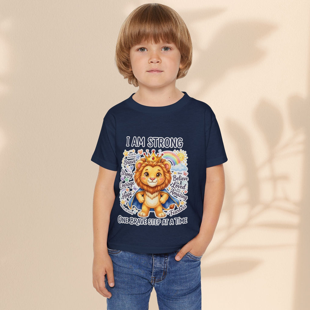 Sea Dragon Dreams toddler t-shirt in navy blue featuring a courageous lion graphic and I Am Strong text on a child
