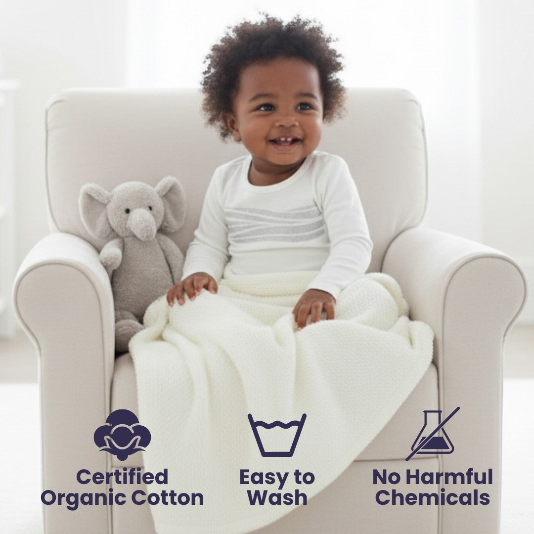 Sea Dragon Dreams toddler wearing a white long-sleeve pajama top with reflective chest detail, sitting in a chair.
