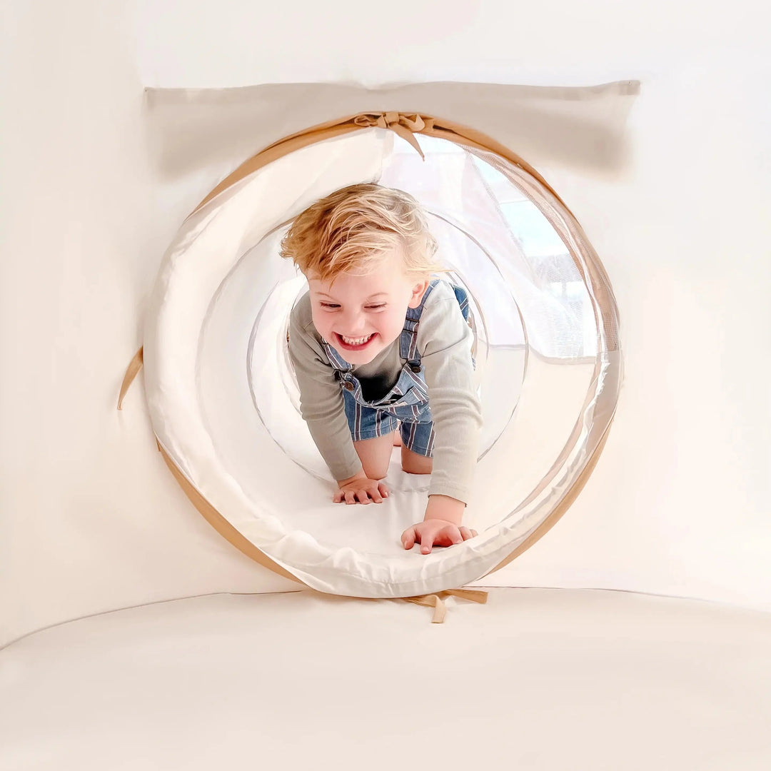 Sea Dragon Dreams toddler crawling through a soft white peachskin polyester play tunnel for indoor adventures