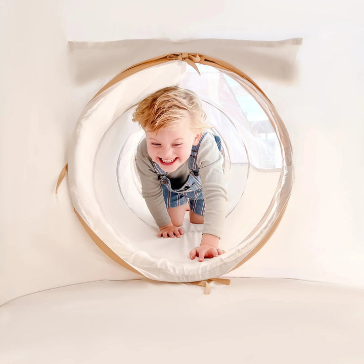 Sea Dragon Dreams toddler crawling through a soft white peachskin polyester play tunnel for indoor adventures