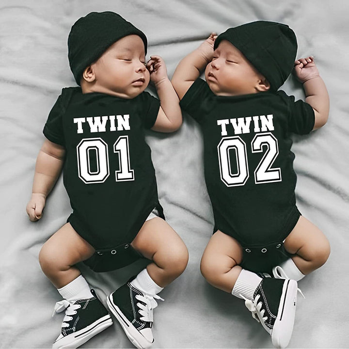 Sea Dragon Dreams newborn twins wearing matching black cotton short-sleeve bodysuits with Twin 01 and 02 print