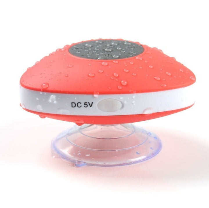Sea Dragon Dreams waterproof red and white Bluetooth shower speaker with a suction cup base covered in water droplets