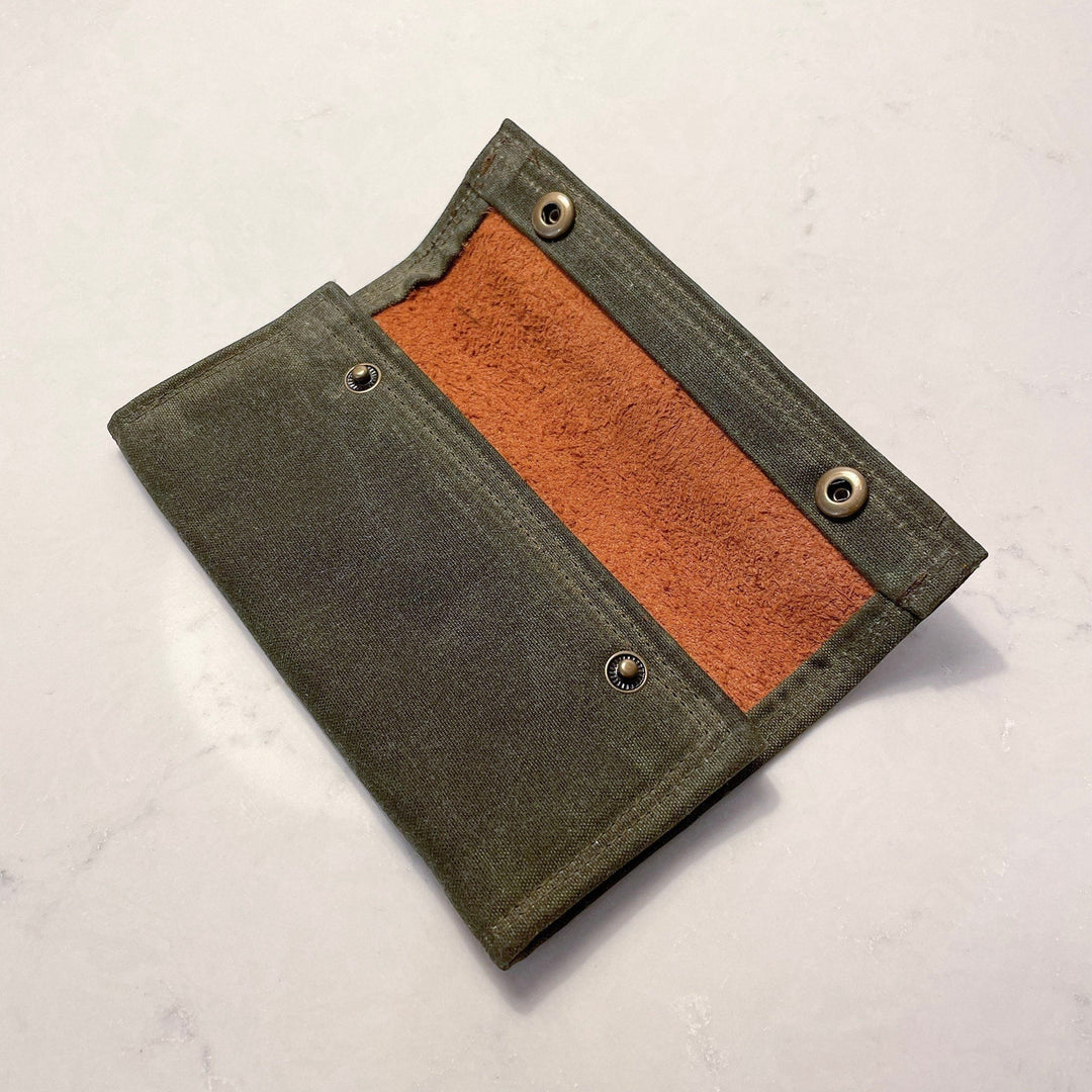 Sea Dragon Dreams waxed canvas fly fishing wallet in olive green with a soft suede interior and brass snap closures.