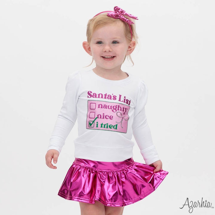 Sea Dragon Dreams white long-sleeve sweatshirt with Santa's List graphic worn by a toddler girl with a pink skirt