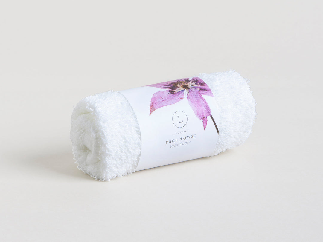 Sea Dragon Dreams white cotton face towel rolled up with a floral paper band for a spa gift set