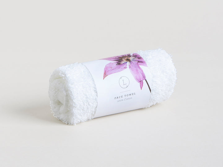 Sea Dragon Dreams white cotton face towel rolled with a floral paper band for a spa-inspired self-care gift set
