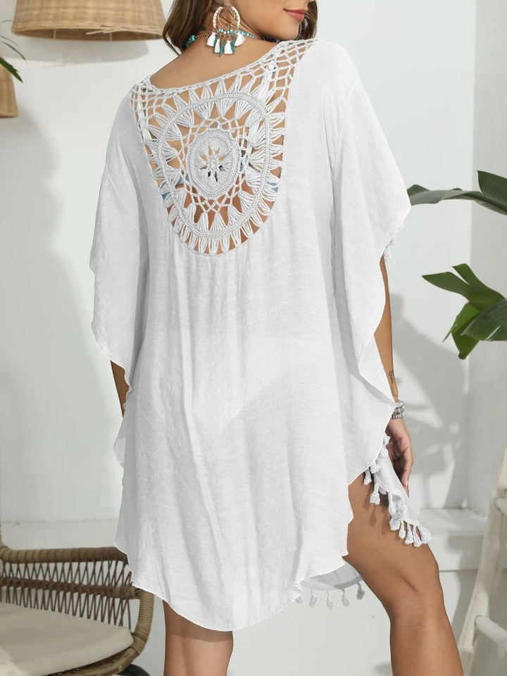 Sea Dragon Dreams white crochet beach cover-up with intricate back cutout and tassel hem worn by a woman