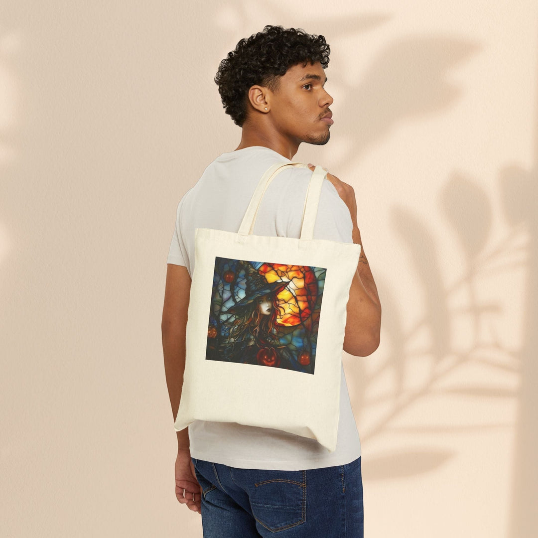 Sea Dragon Dreams cotton canvas tote bag with witchy Halloween art, worn over the shoulder by a man in a white tee.