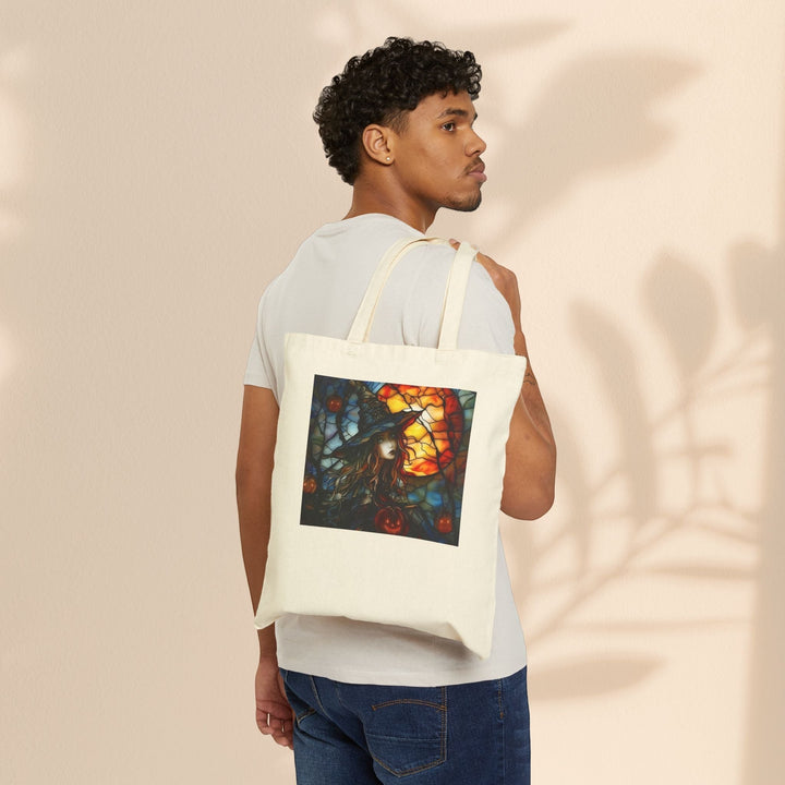 Sea Dragon Dreams cotton canvas tote bag with witchy Halloween art, worn over the shoulder by a man in a white tee.