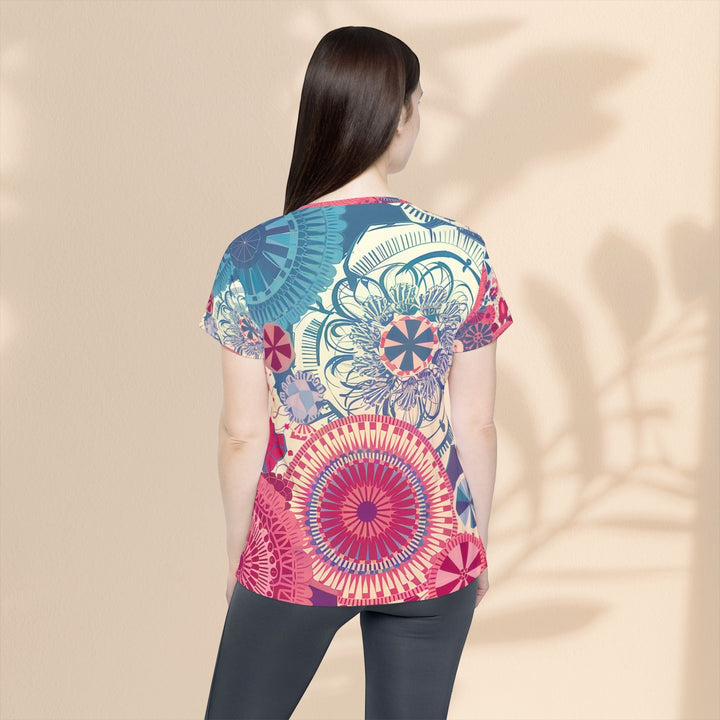 Woman wearing a Sea Dragon Dreams moisture-wicking sports jersey with a vibrant, colorful mandala-inspired pattern.