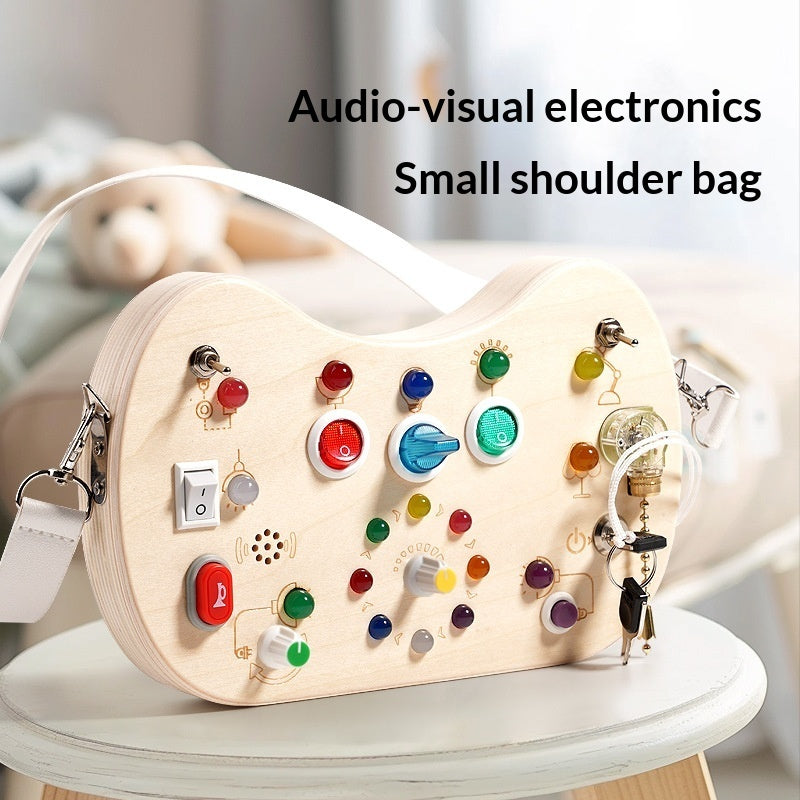 Sea Dragon Dreams wooden busy board shoulder bag with colorful LED lights, switches, and buttons for sensory play