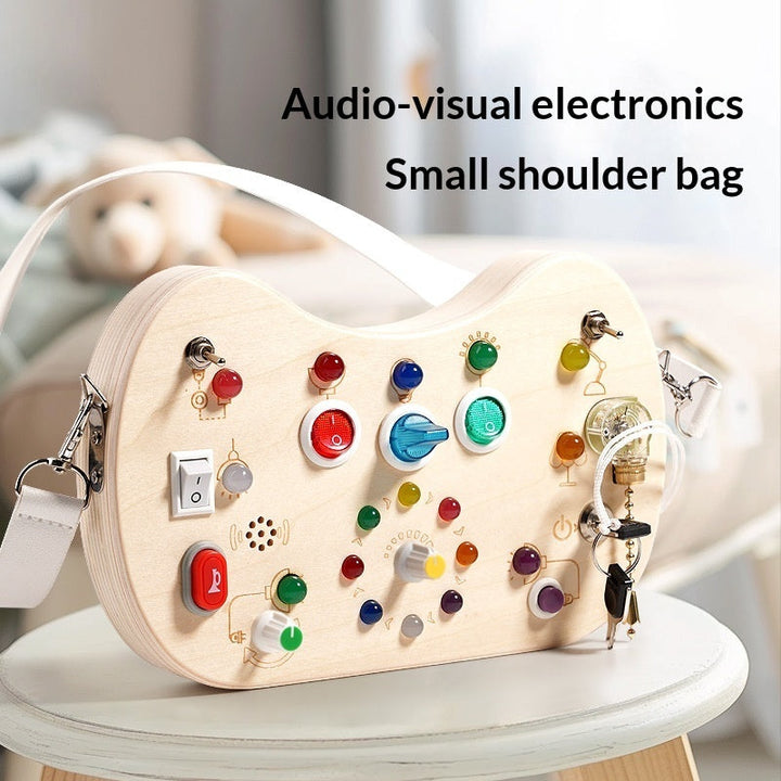Sea Dragon Dreams wooden busy board shoulder bag with colorful LED lights, switches, and buttons for sensory play