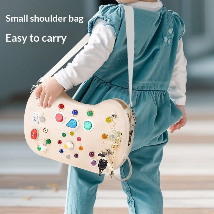 Sea Dragon Dreams wooden busy board shoulder bag with colorful LED lights, switches, and buttons for sensory play