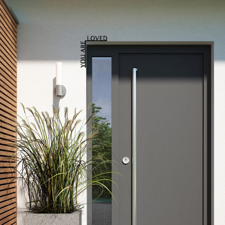 Sea Dragon Dreams You Are Loved wooden corner quote sign mounted above a modern grey front door with a tall planter.