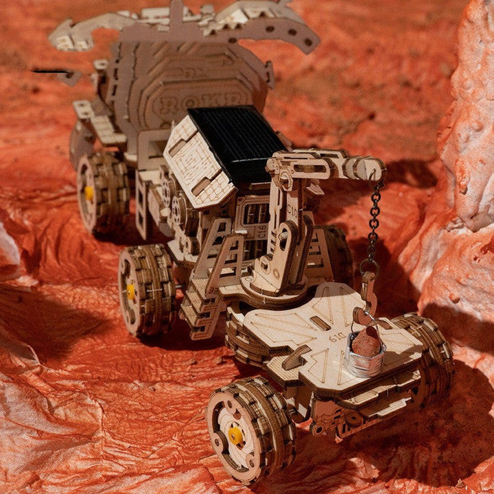 Sea Dragon Dreams wooden mechanical rover puzzle toy with intricate gear details on a textured orange surface