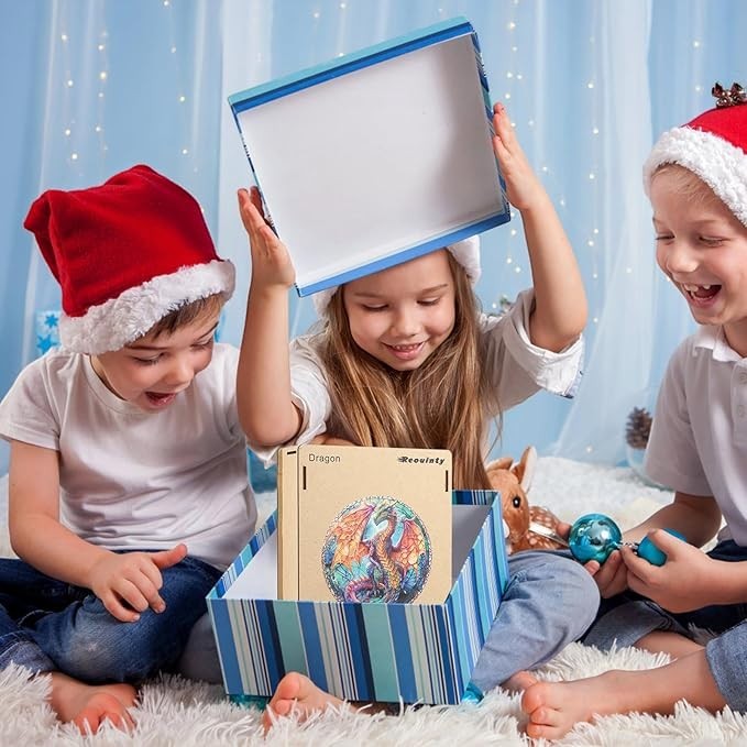 Three children in Santa hats excitedly opening a Sea Dragon Dreams 500-piece wooden dragon jigsaw puzzle gift box.