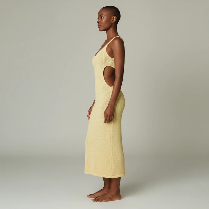 Sea Dragon Dreams backless yellow scoop neck cover-up dress with side cutouts on a model, side profile view.