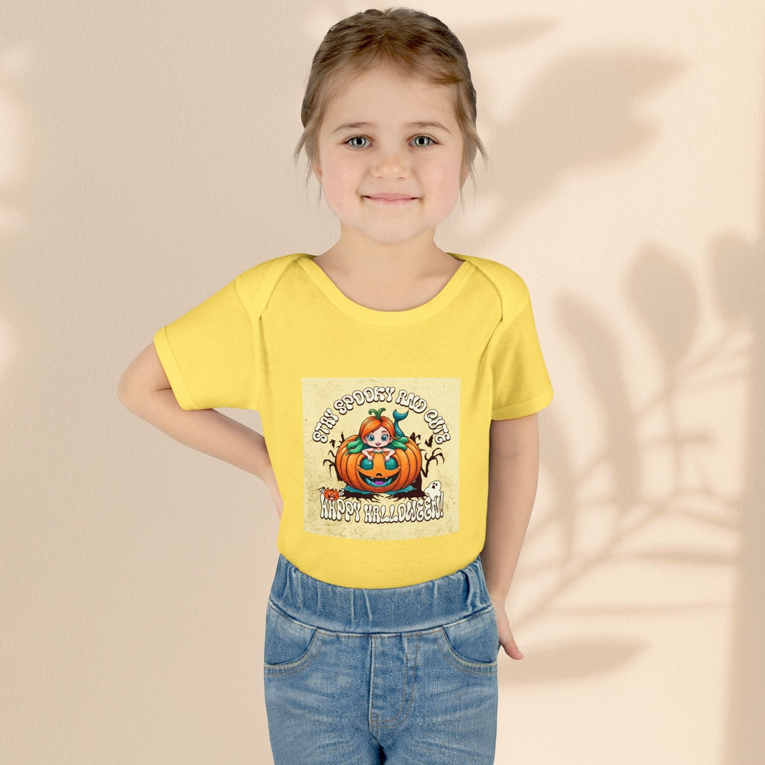 Sea Dragon Dreams infant bodysuit in yellow with a Stay Spooky and Cute pumpkin graphic worn by a young girl