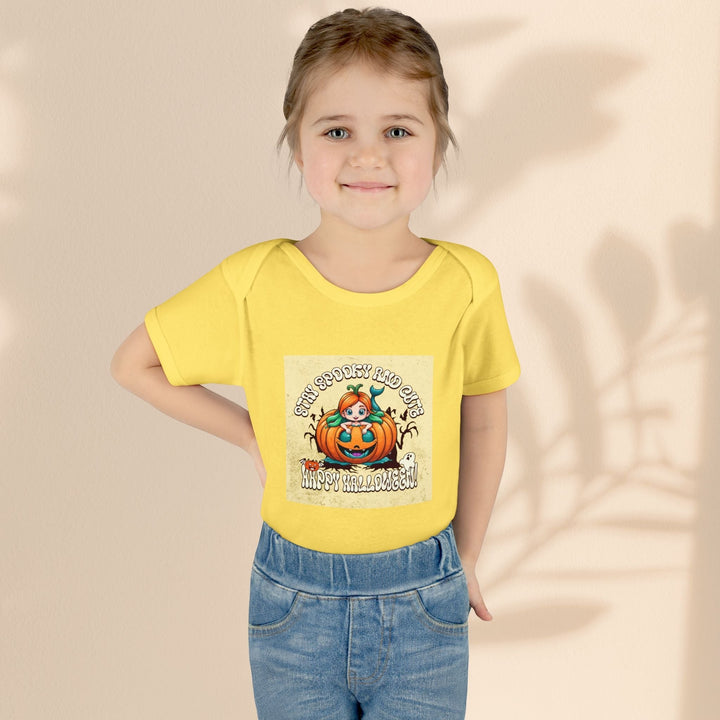 Sea Dragon Dreams infant bodysuit in yellow with a Stay Spooky and Cute pumpkin graphic worn by a young girl