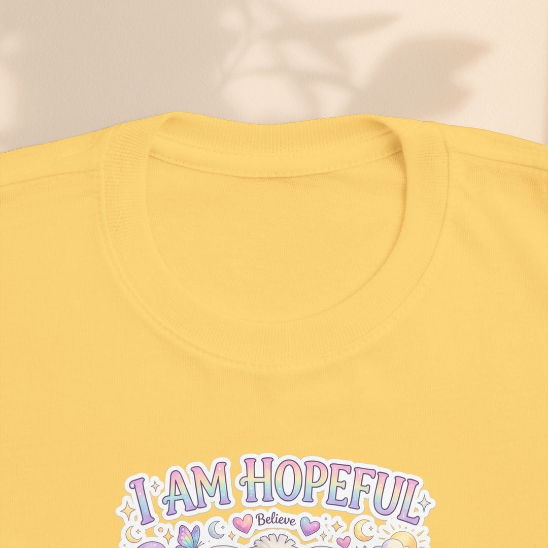 Sea Dragon Dreams yellow toddler tee featuring the Hope Bunny graphic and I Am Hopeful text in pastel colors.