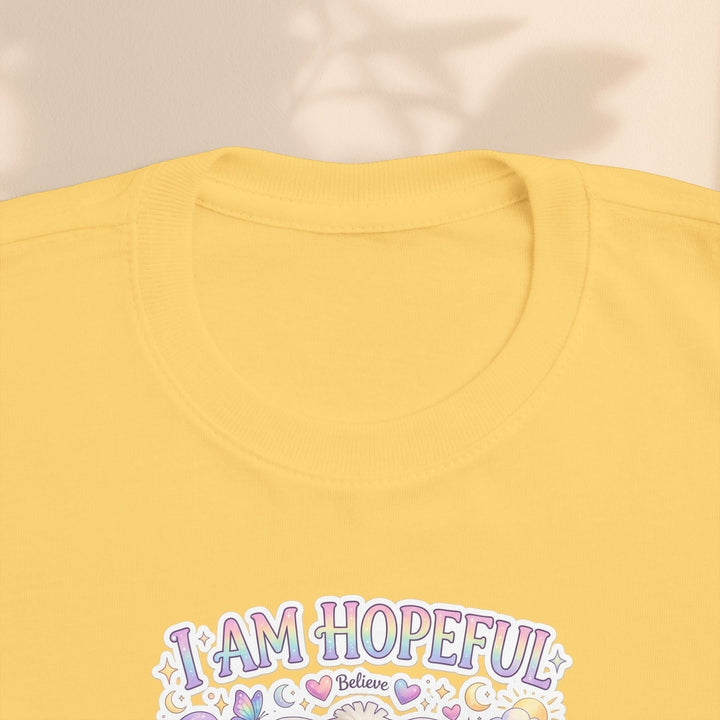 Sea Dragon Dreams yellow toddler tee featuring the Hope Bunny graphic and I Am Hopeful text in pastel colors.