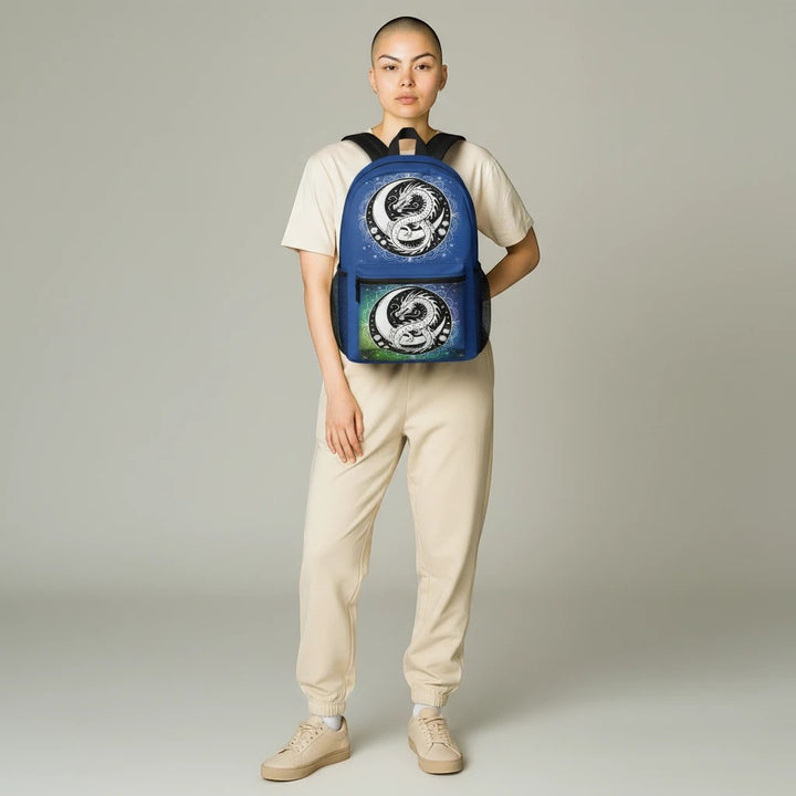 Model wearing a Sea Dragon Dreams backpack featuring a blue and green yin-yang dragon design on a neutral outfit.