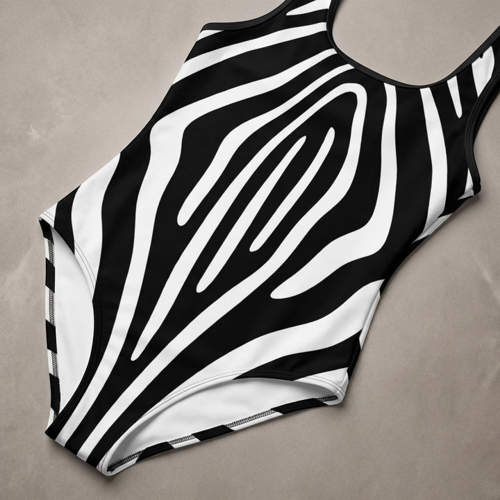 Sea Dragon Dreams one-piece swimsuit featuring a bold black and white zebra stripe pattern with a U-shaped neckline.
